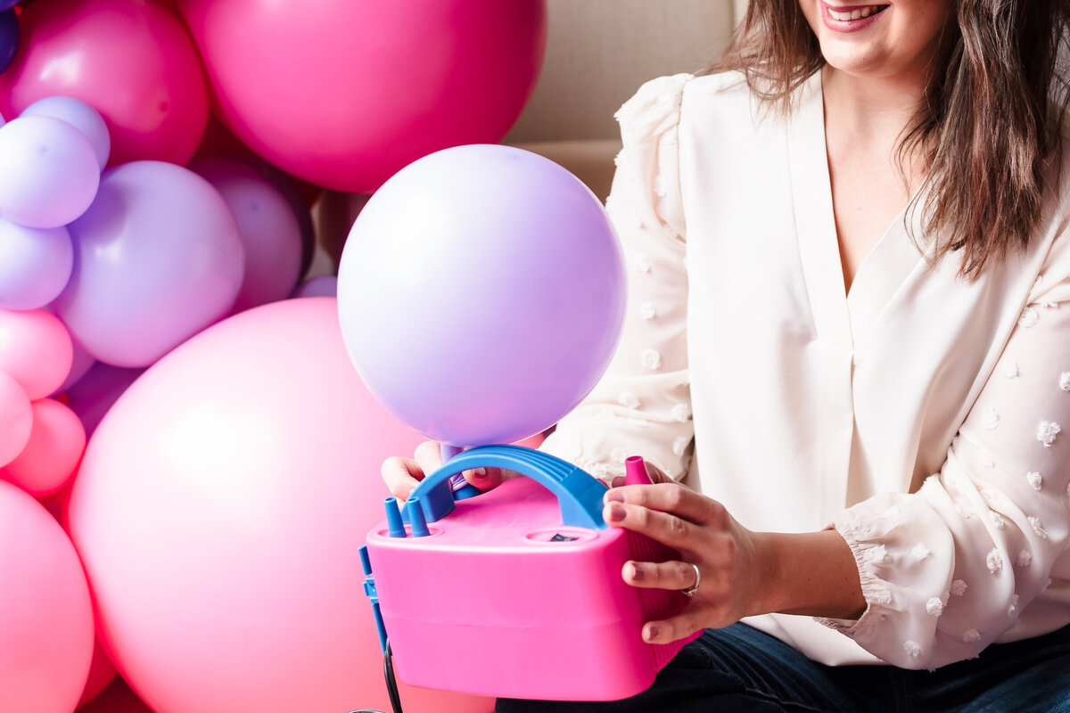 woman inflate a balloon using a machine