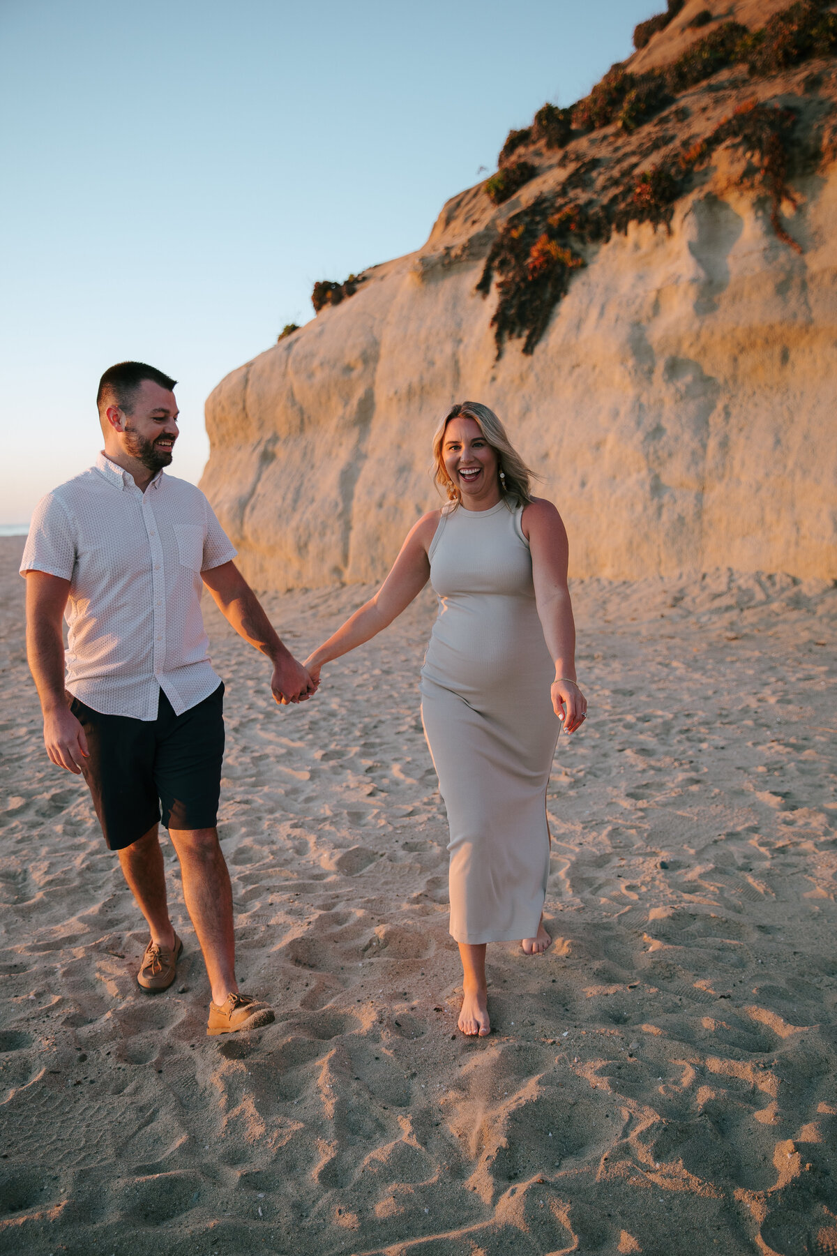 Expecting couple holding hands during San Diego maternity shoot
