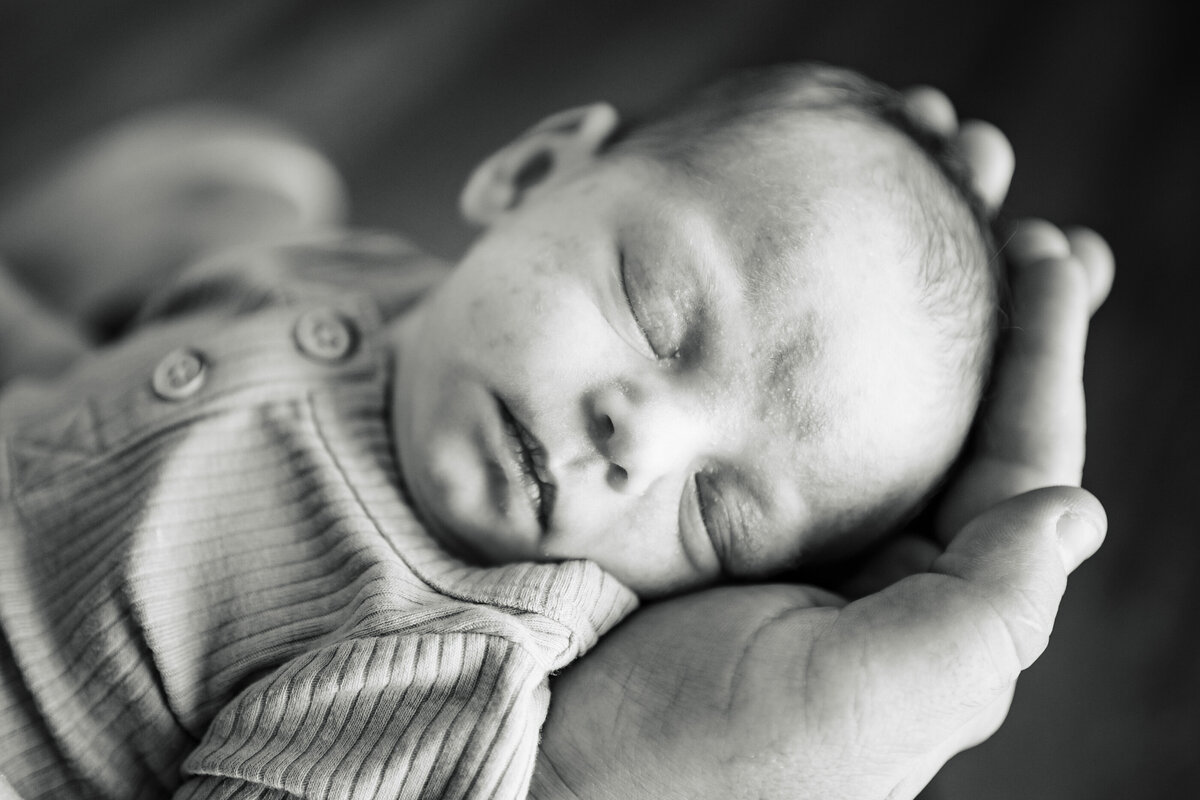 close up of baby in hands lifestyle newborn photography session