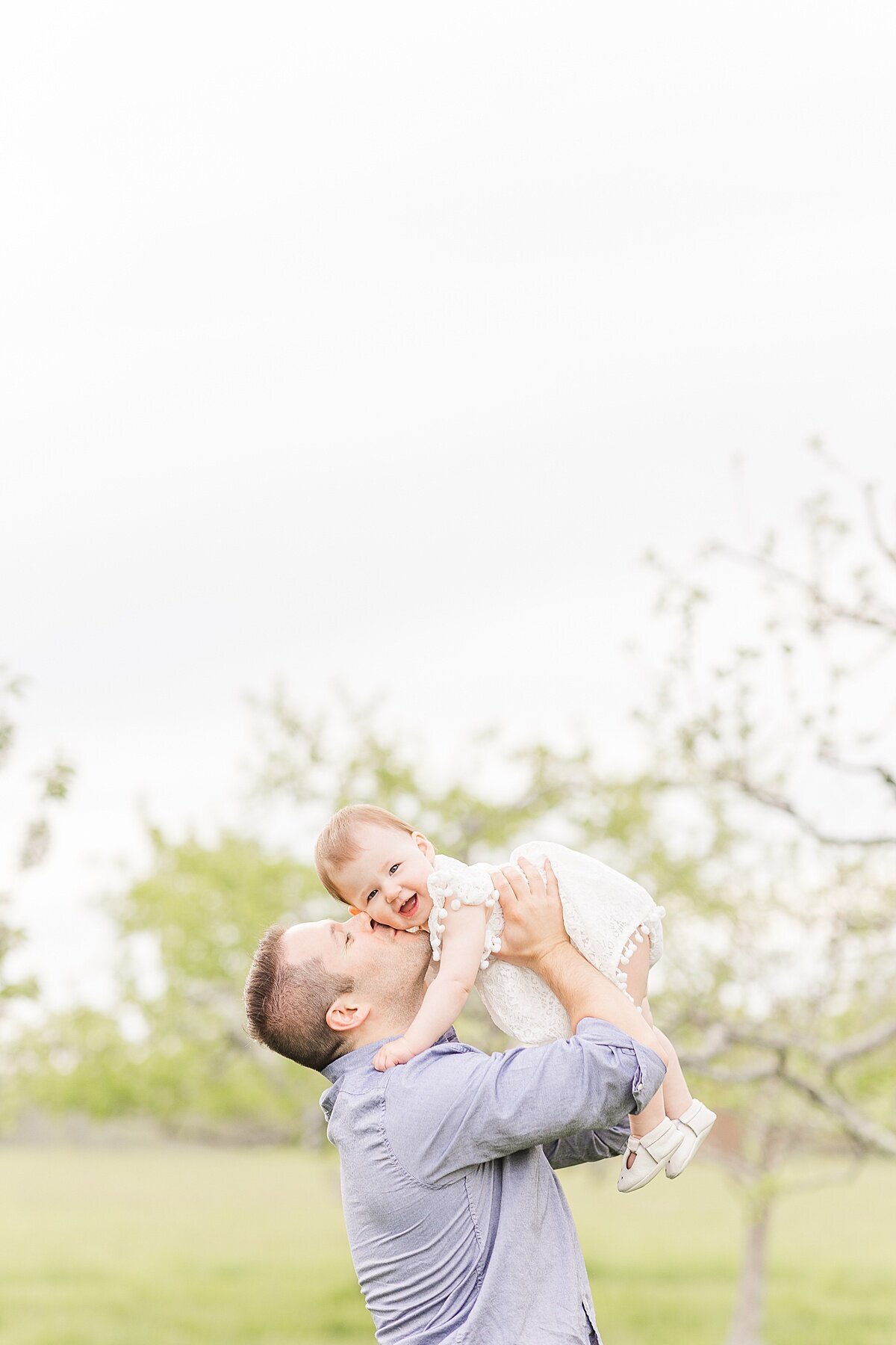 dad kisses daughter    during Family photo session with Sara Sniderman Photography in Natick Massachusetts