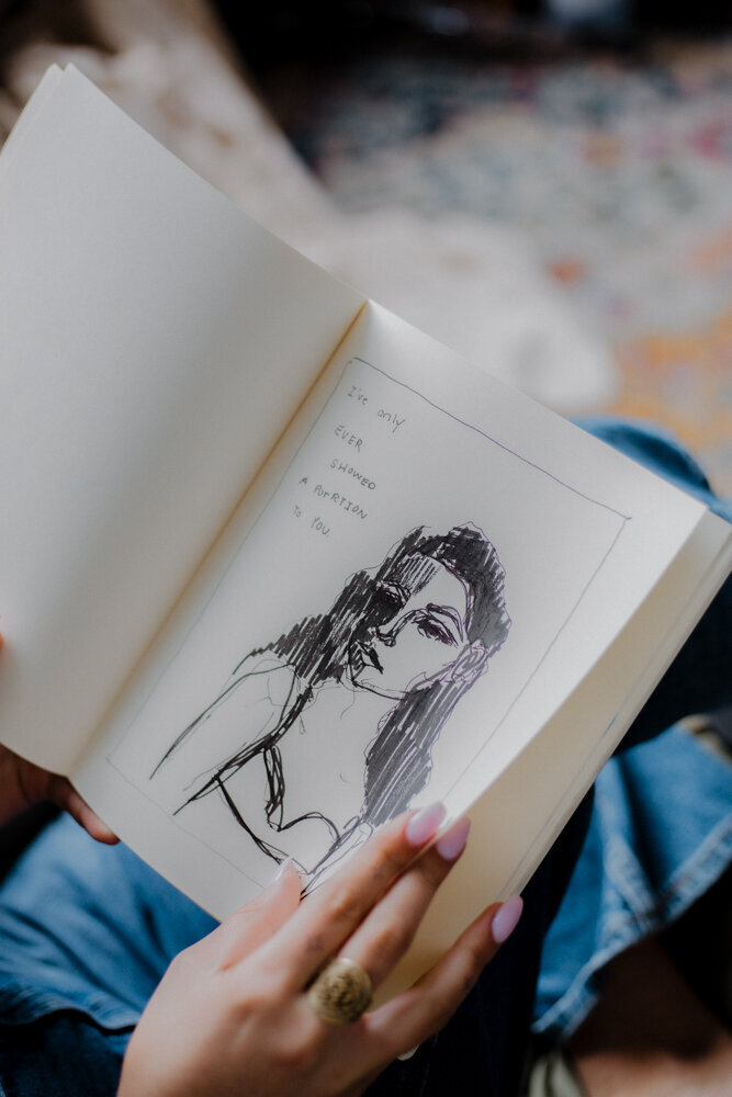flipping through a sketch in a notebook