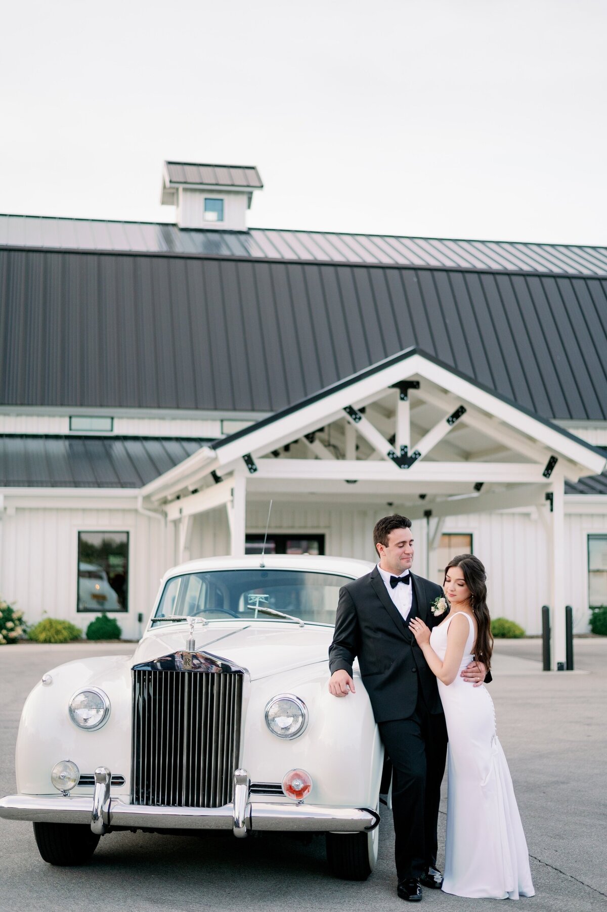 bride and groom posing in front of a vintage car