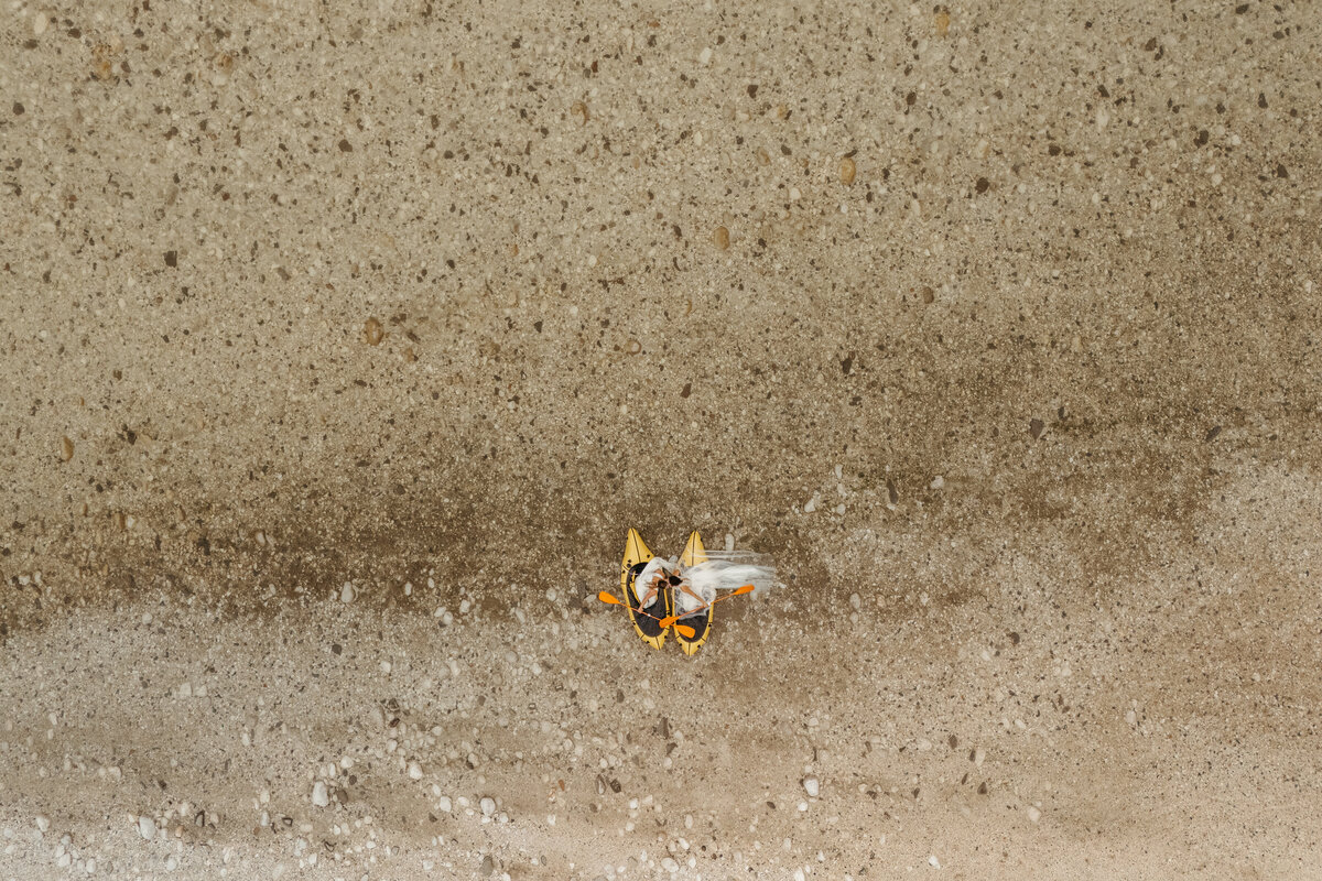Aerial view of brides in yellow packraft in Soča Valley river elopement