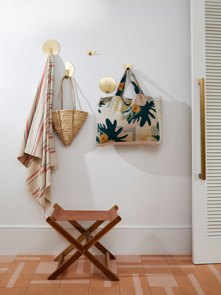 Entryway interior styling Melbourne with linen tote bag, striped throw, and timber stool by residential design interior stylist.
