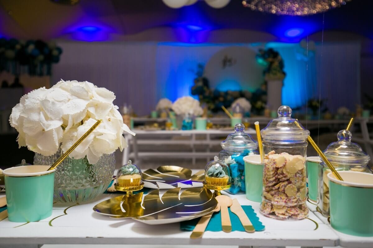 Kids party table with sweet jar, cup cake, cup, plate and floral display