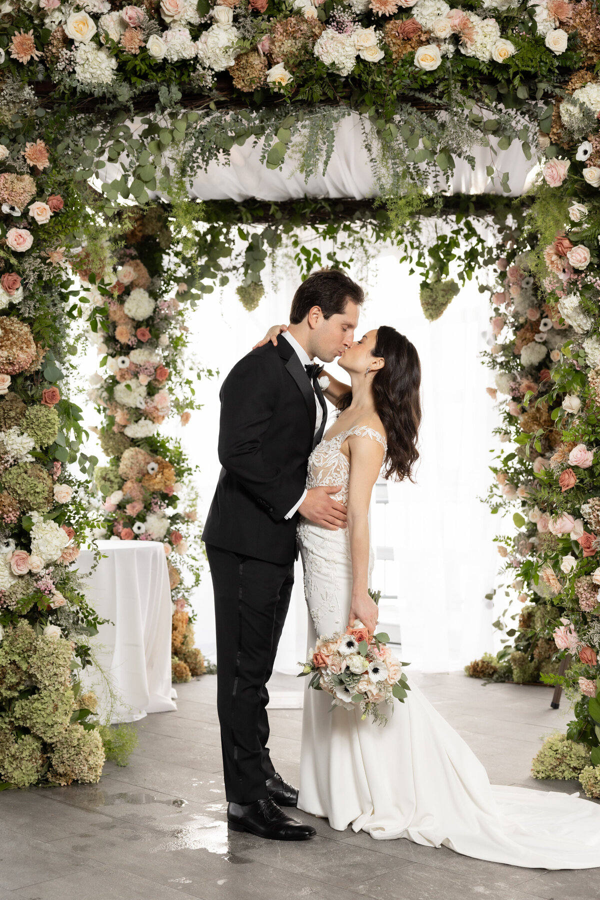 sarah & mark kiss underneath their chuppah during their wedding portraits