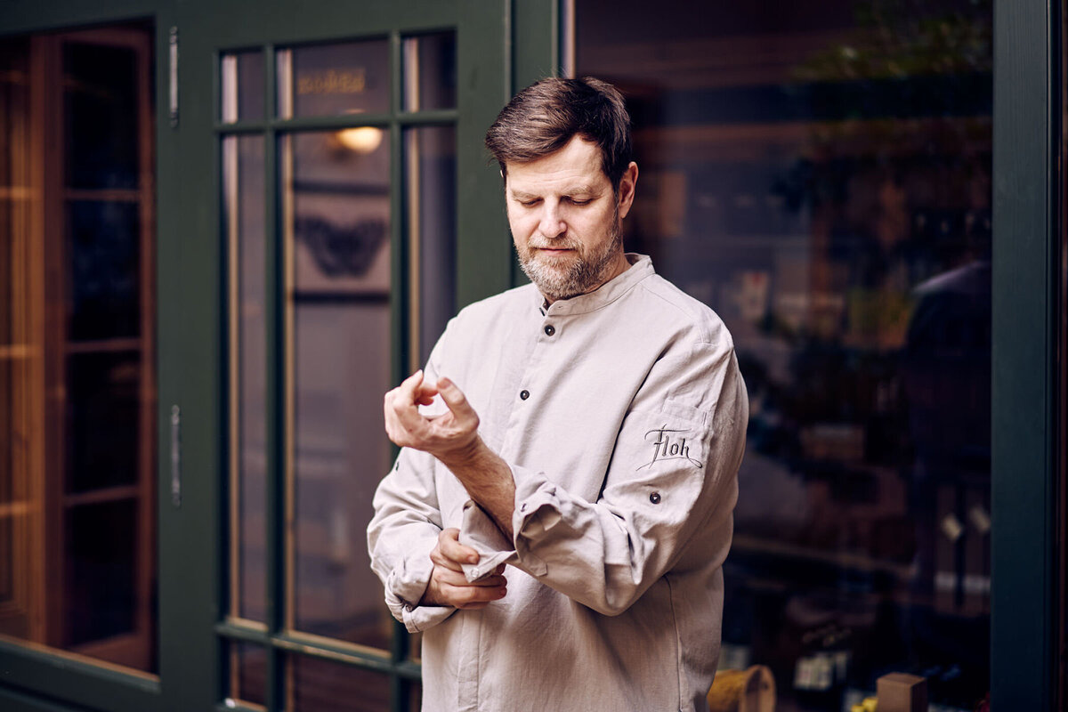 Businessportrait eines Küchenchefs vor seinem Restaurant – Atelier Schulte fotografiert Persönlichkeiten aus Gastronomie und Tourismus in ganz Österreich.