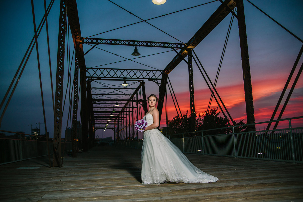 bride with sunset behind her on hays street bridge in downtown San Antonio for her bridal session