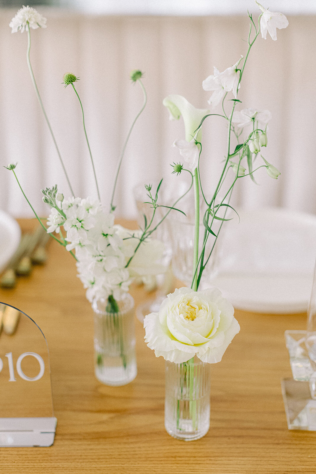 A closeup of bud vases at a Willow Inn wedding, featuring elegant, airy white flowers. 