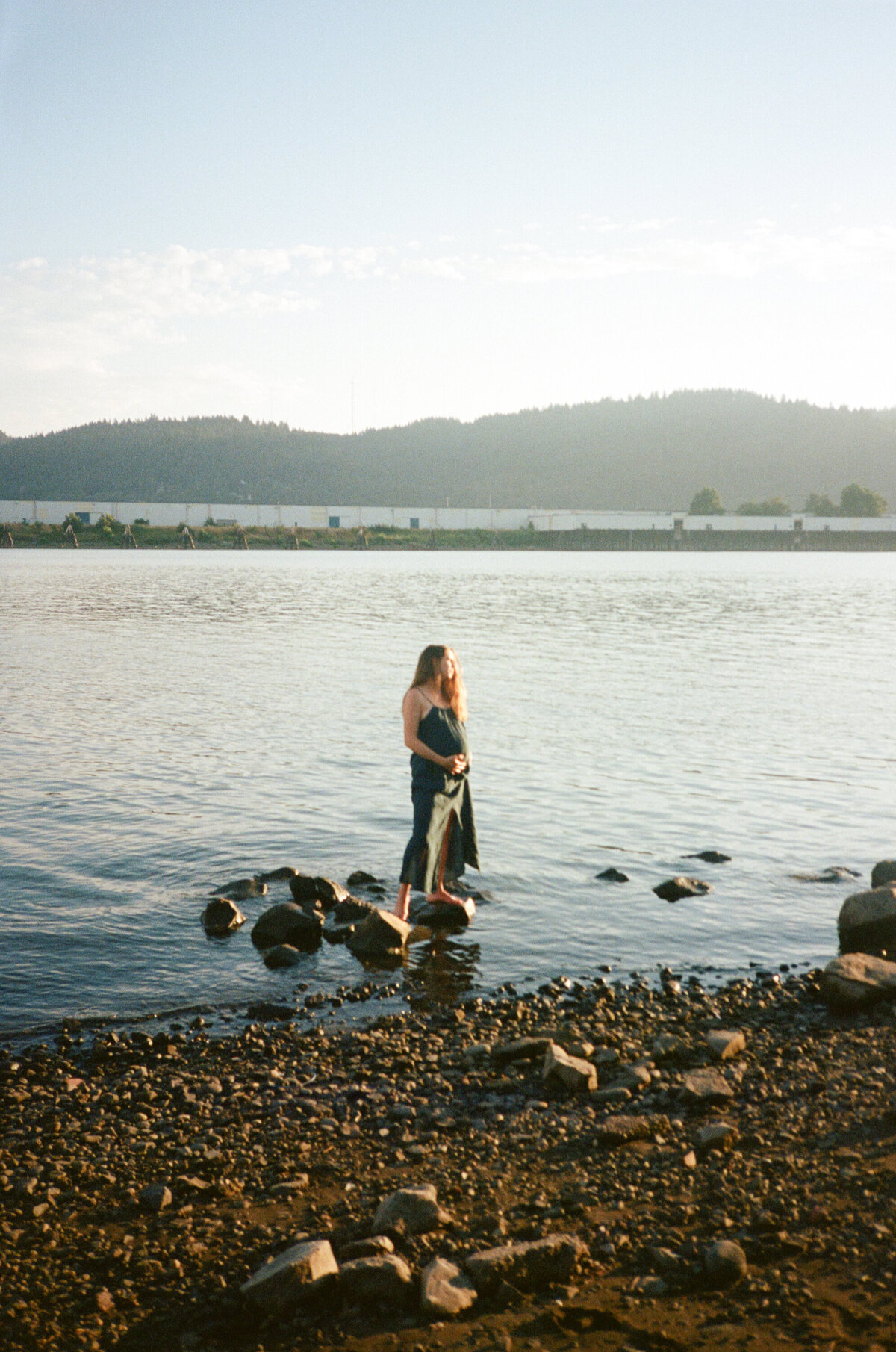 soon to be pregnant mother standing in the river in north portland