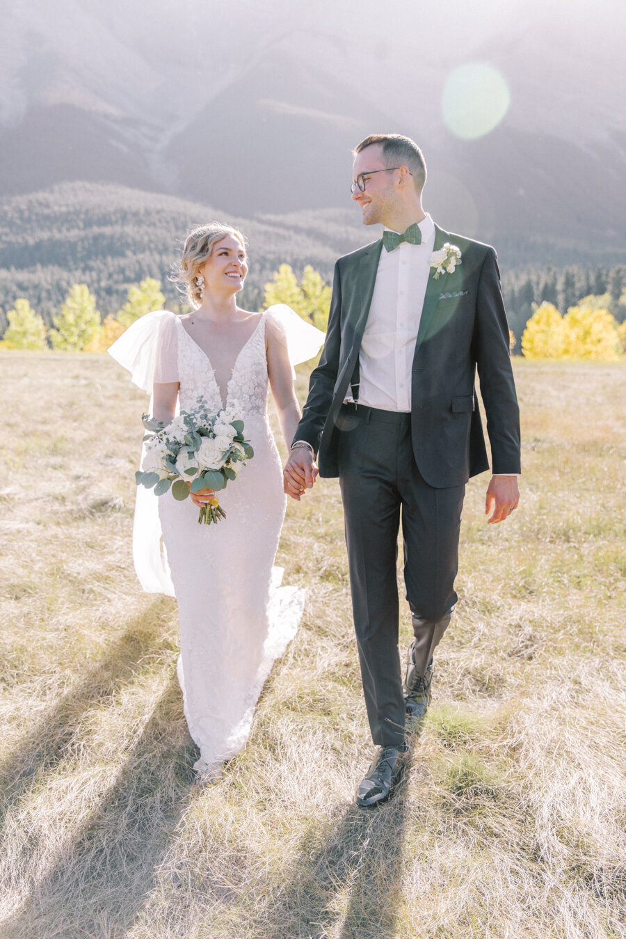 A bride and groom walking in the mountains during their Calgary wedding day