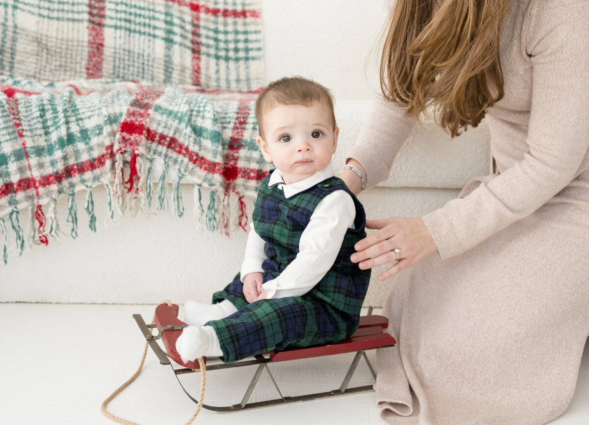 Baby posed on sleigh for holiday photos