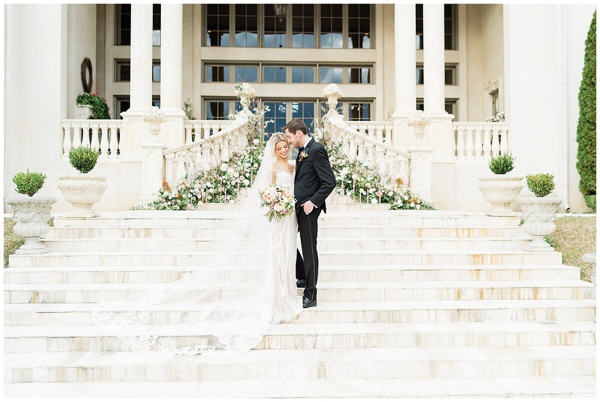 Bride and groom standing on white stairs