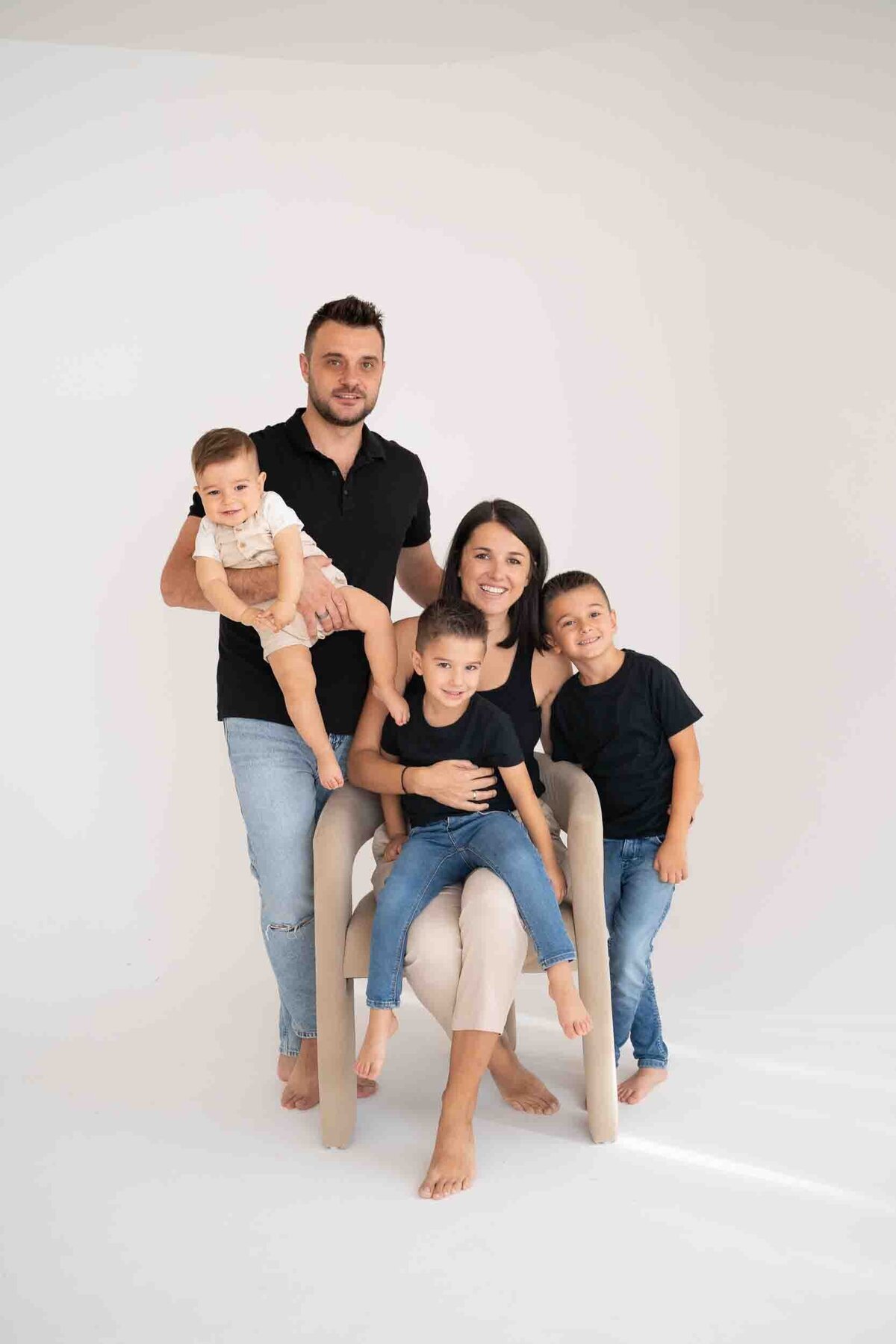 family at StudioStudio Ann Arbor with mom sitting in chair with three children and dad surrounding her