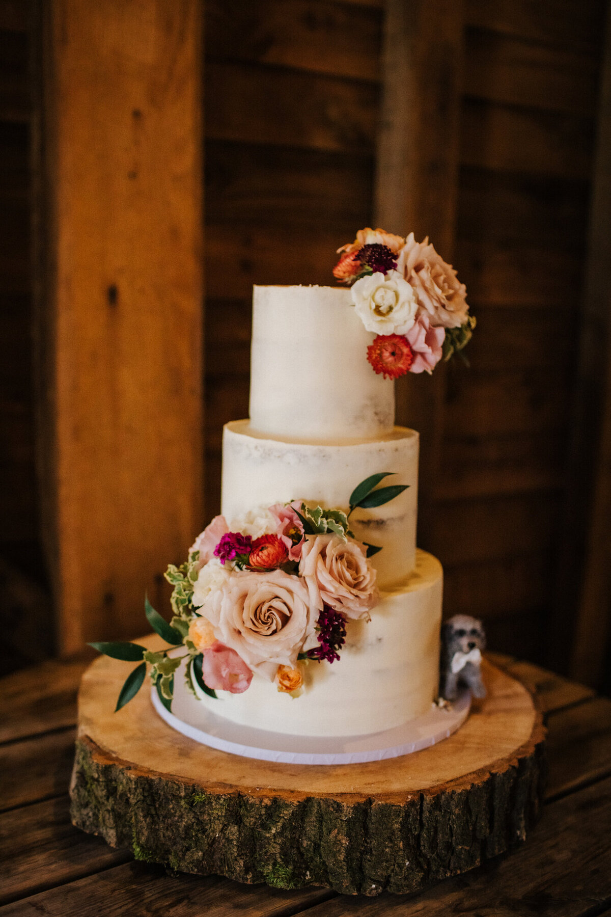 layers-graces-weddingcake-flowermeadow-threetier-flowers-buttercream-semi-naked-barn-2