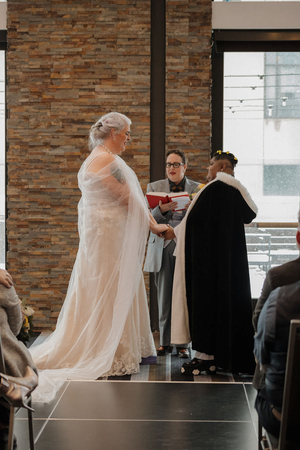 A wedding couple holding hands and saying their vows.