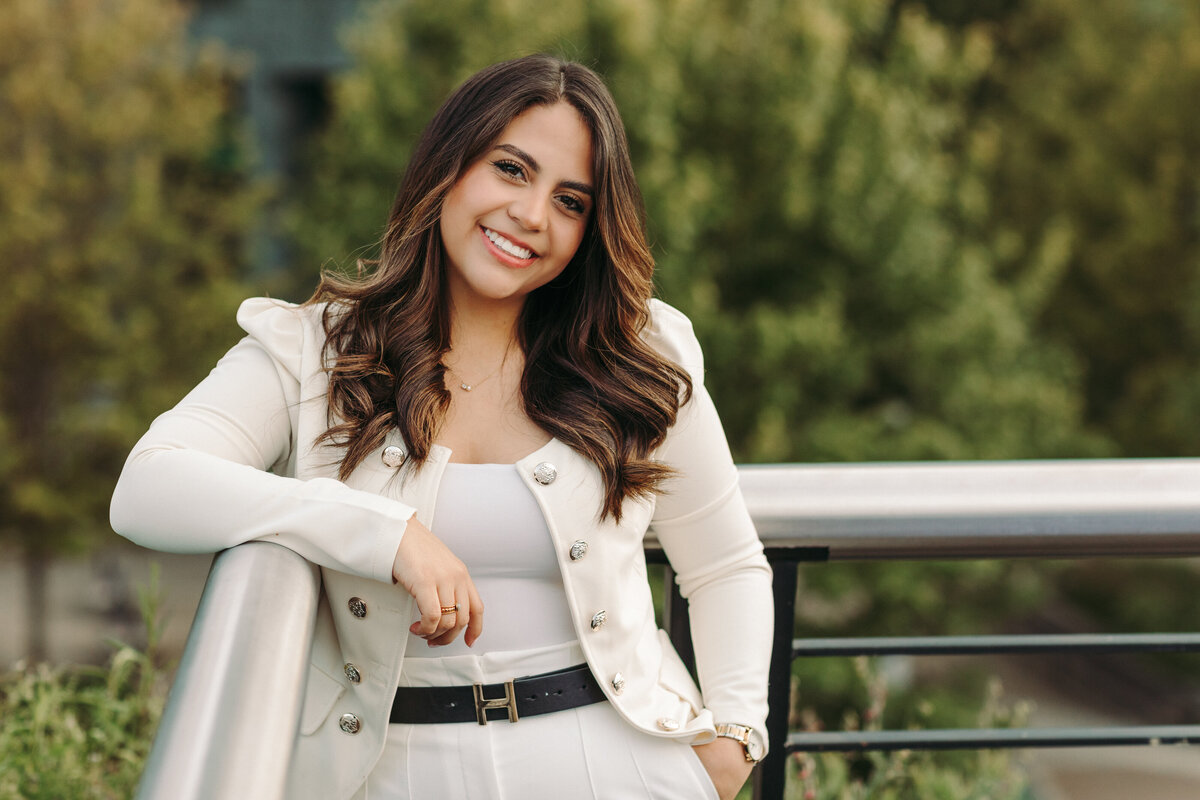 Utah Family Photographer captures woman smiling wearing white outfit holding item