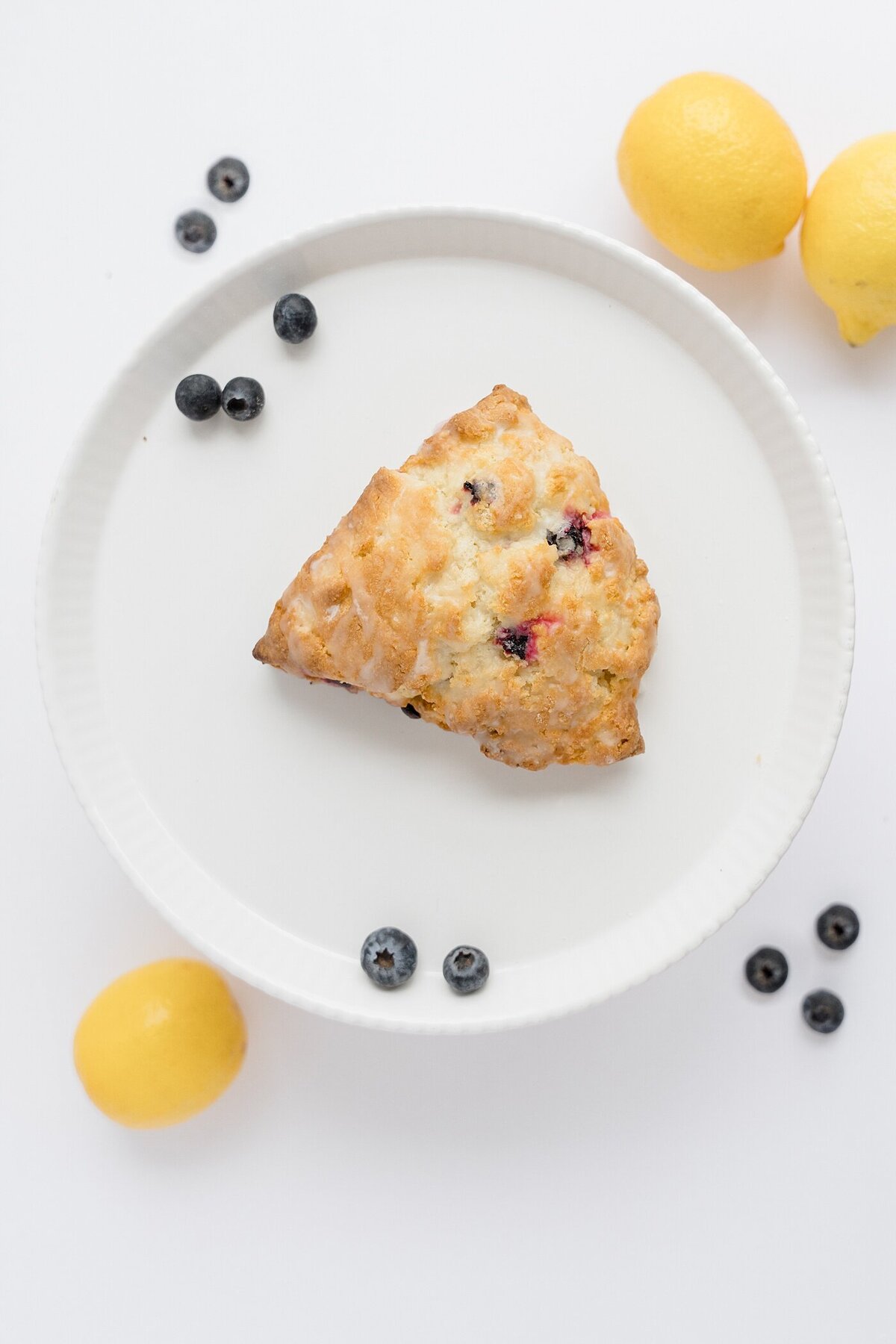 product photography for small business with a pastery sitting on a plate surrounded by blueberries and lemons captured by Columbus photographer