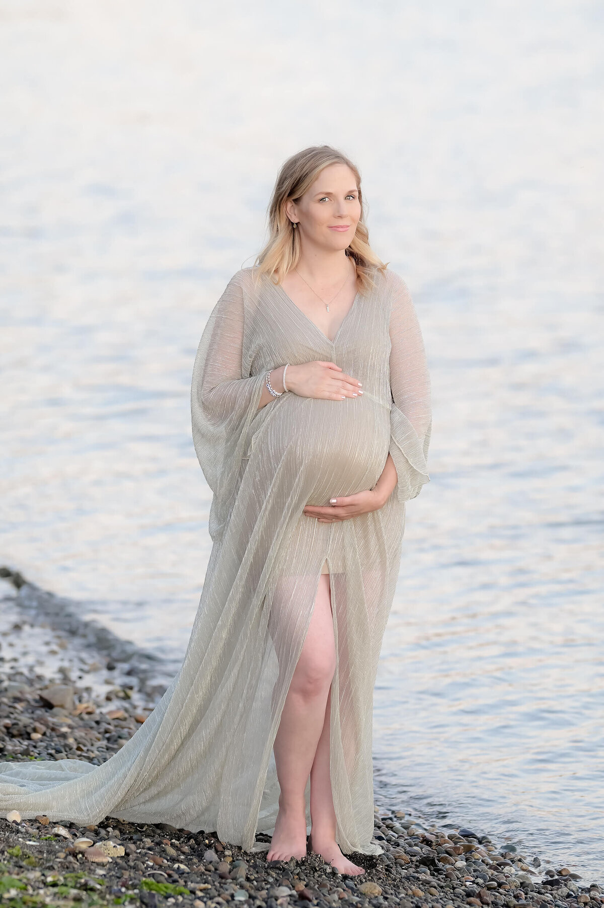 Soft and serene maternity photography on a rocky PNW beach. The light and airy tones perfectly highlight the beauty of the mom-to-be.