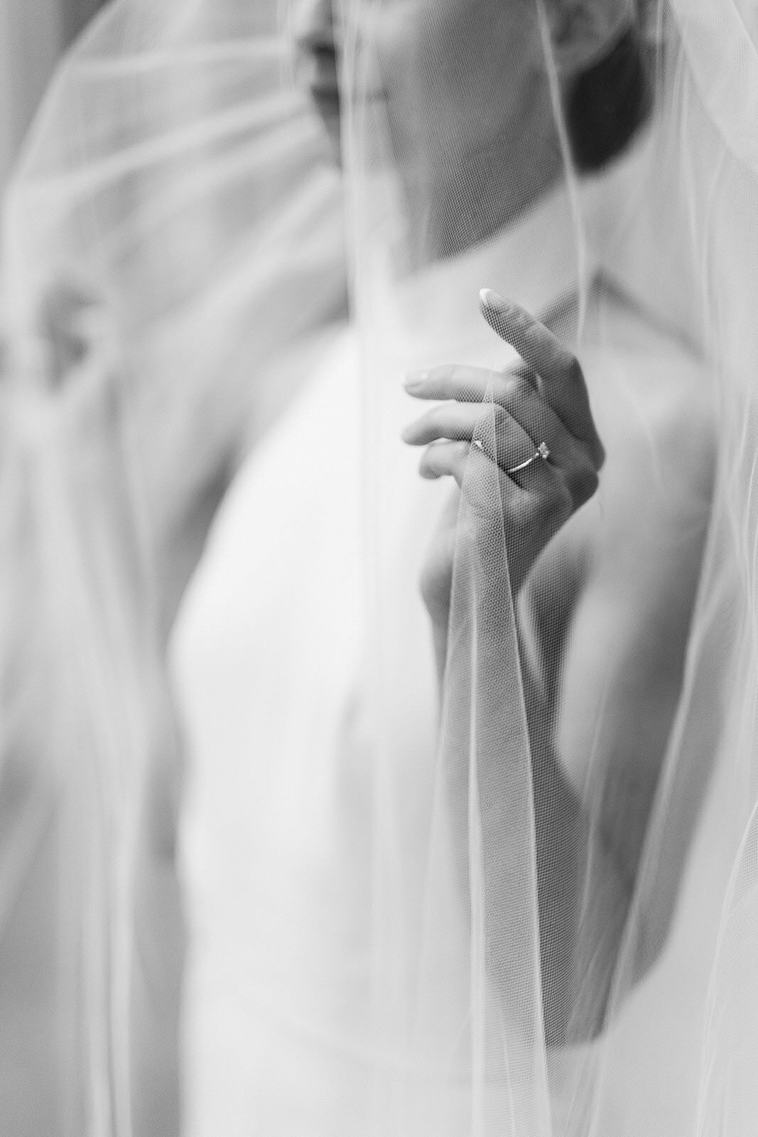 Mariée tient son voile, et elle montre sa bague de mariage. 