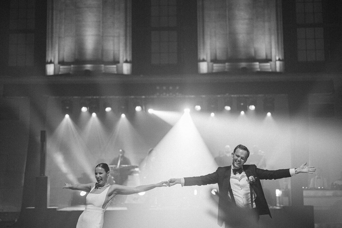 Les mariés font leur première danse dans la salle de réception de mariage : le Théâtre St-James, Vieux Montréal. Mariage élégant.