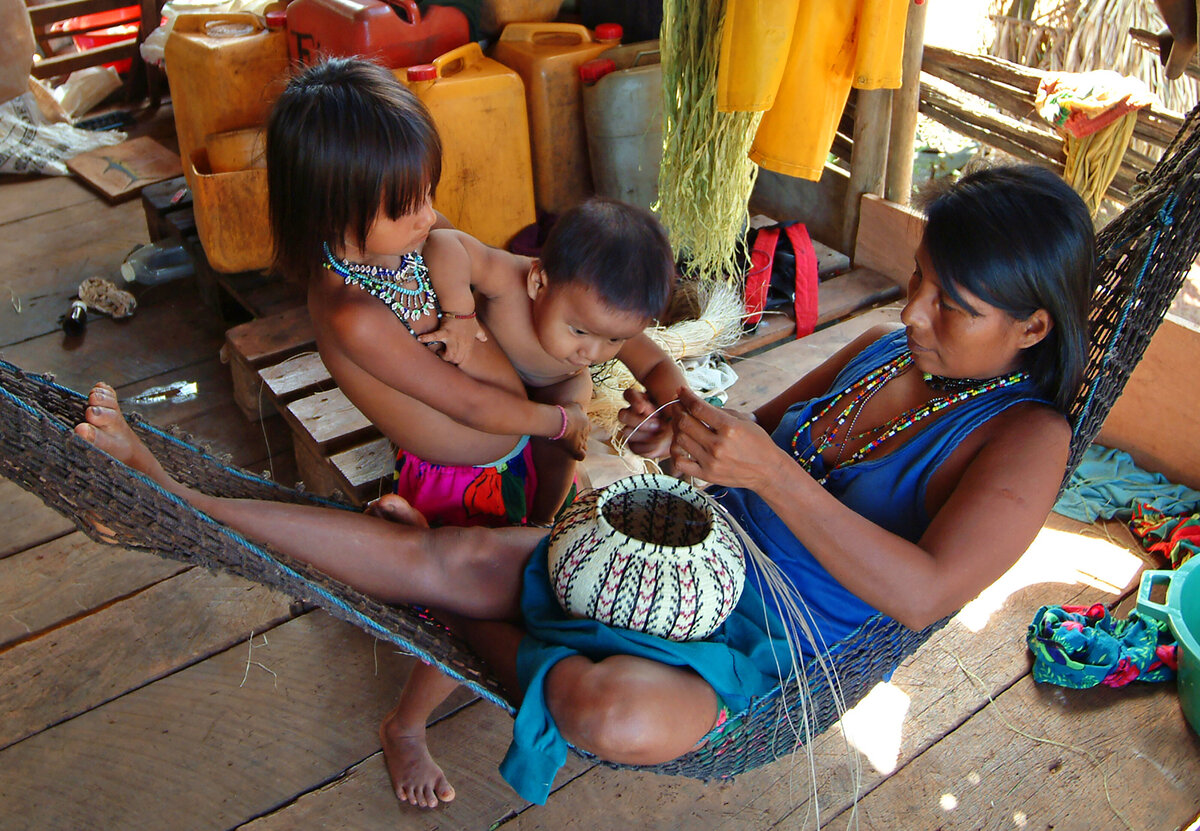 Weaver creates a Hosig Di basket as her children look on
