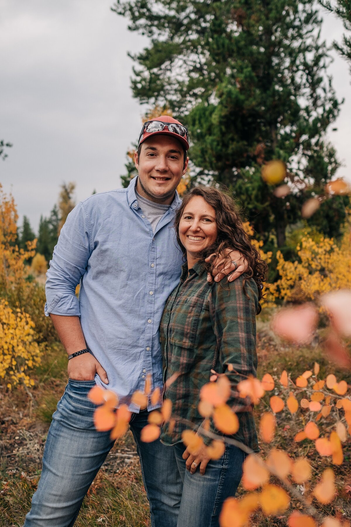 Couple smiling at camera with fall colors