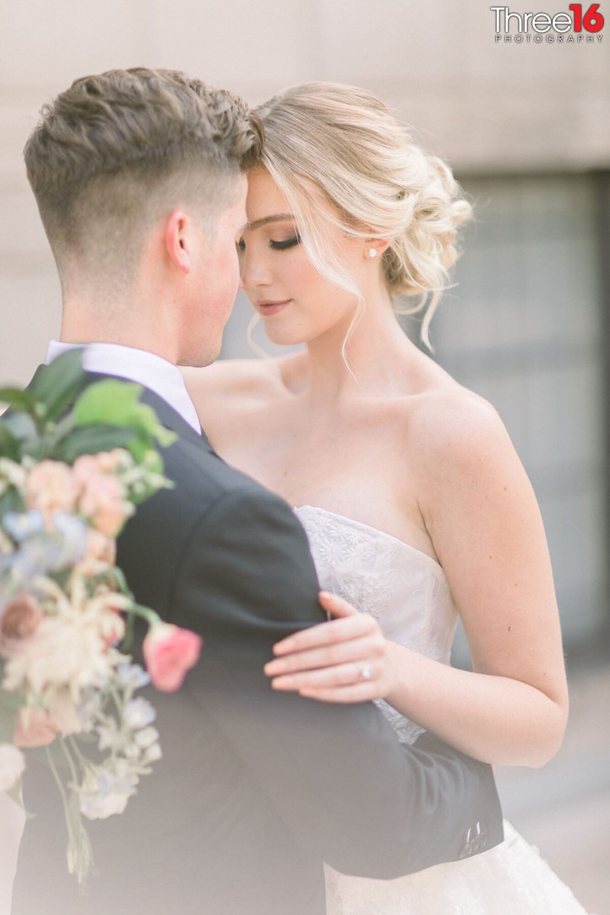 Sweet tender moment between newly married couple as their eyes are closed and foreheads are touching