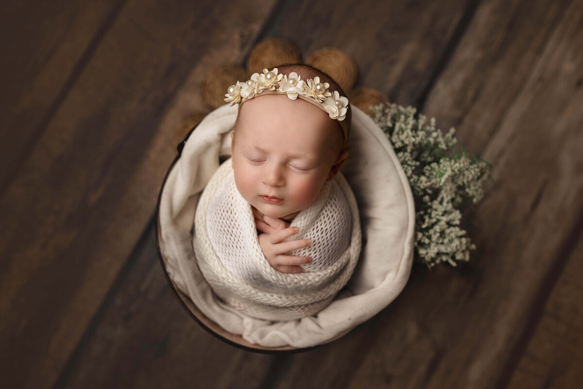 Newborn in bowl with baby's breath