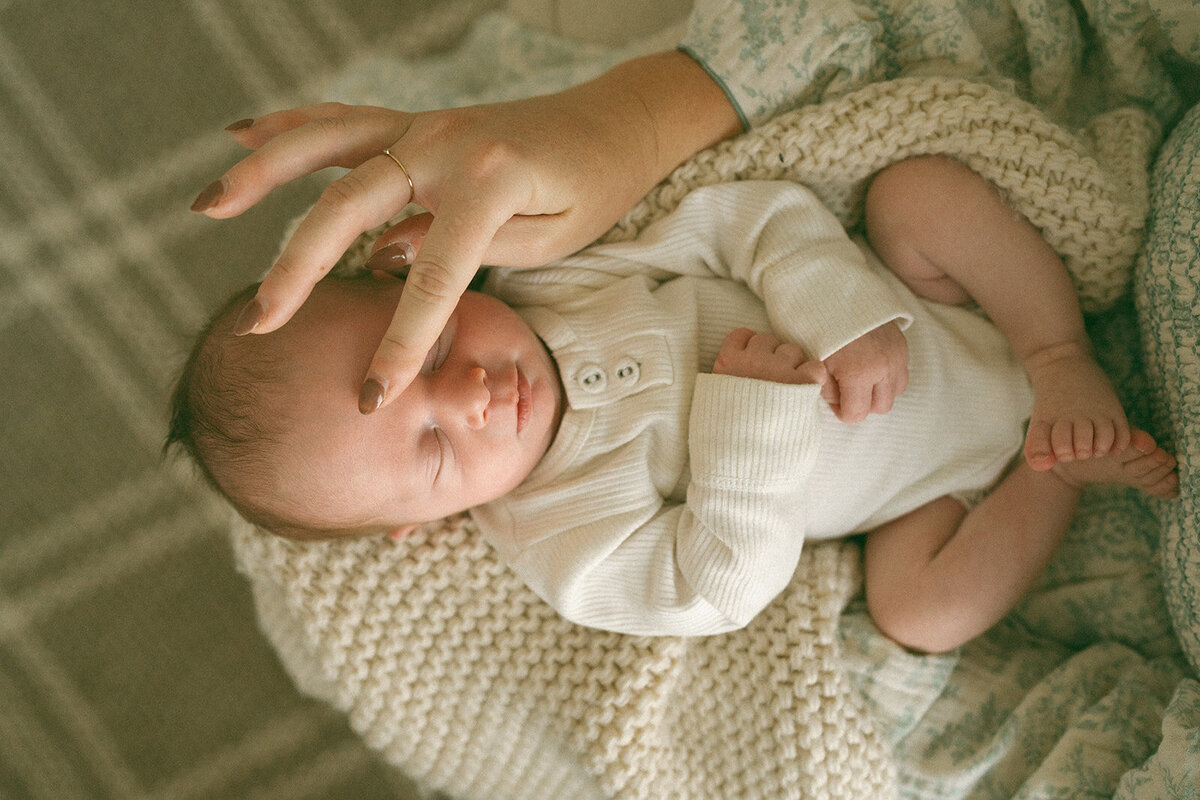 Top-down view of mother gently rubbing her newborn’s nose during an in-home lifestyle photo session in Northern Virginia