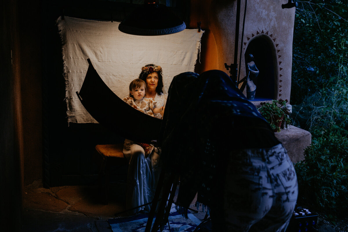 bride and her daughter getting a tintype portrait done during their wedding reception