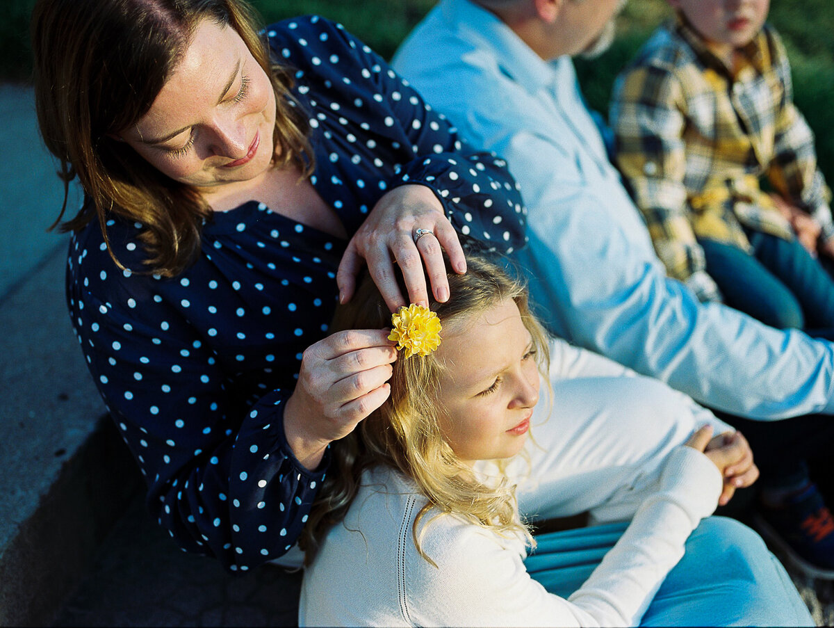 a mom fixes her daughter's hair during a photography session