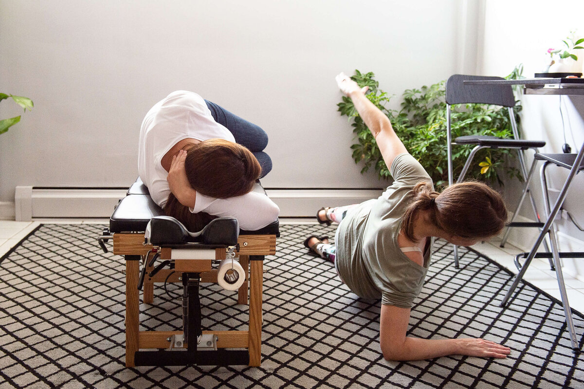a female chiropractor in a white shirt demonstrates a floor exercise to her family patient.  Captured by Ottawa Branding Photographer JEMMAN Photography Commercial