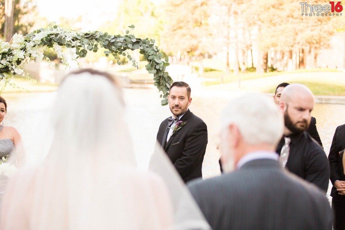 Groom watches his Bride walking towards the altar
