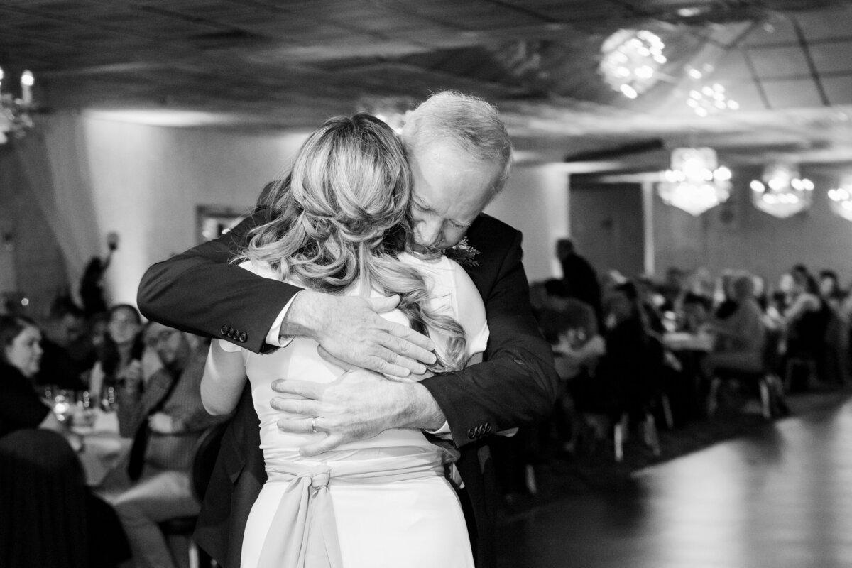 Bride and her father share a tender moment and embrace one another after the father daughter dance on her wedding day. Wedding reception held at Tiffany Banquet Hall in Brookfield Township, Ohio. Photographed by Aaron Aldhizer