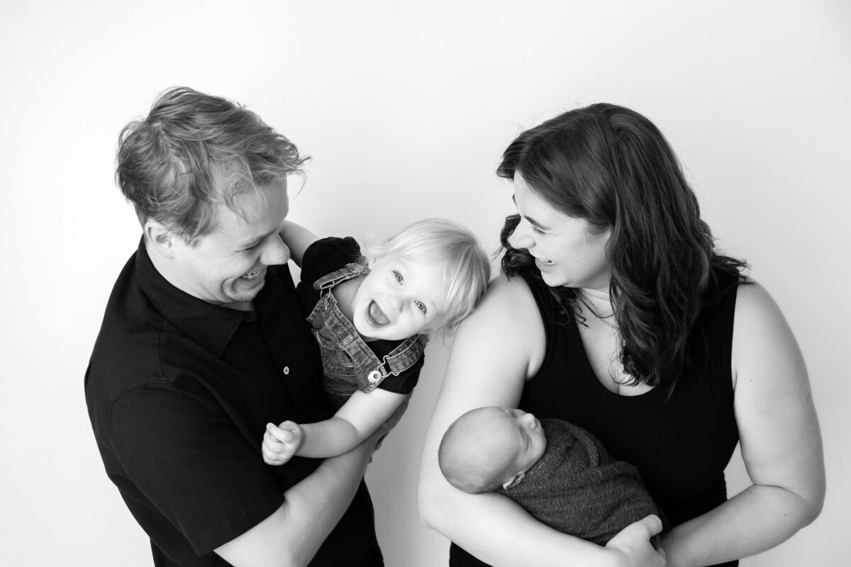 Black and white studio family pose with a toddler