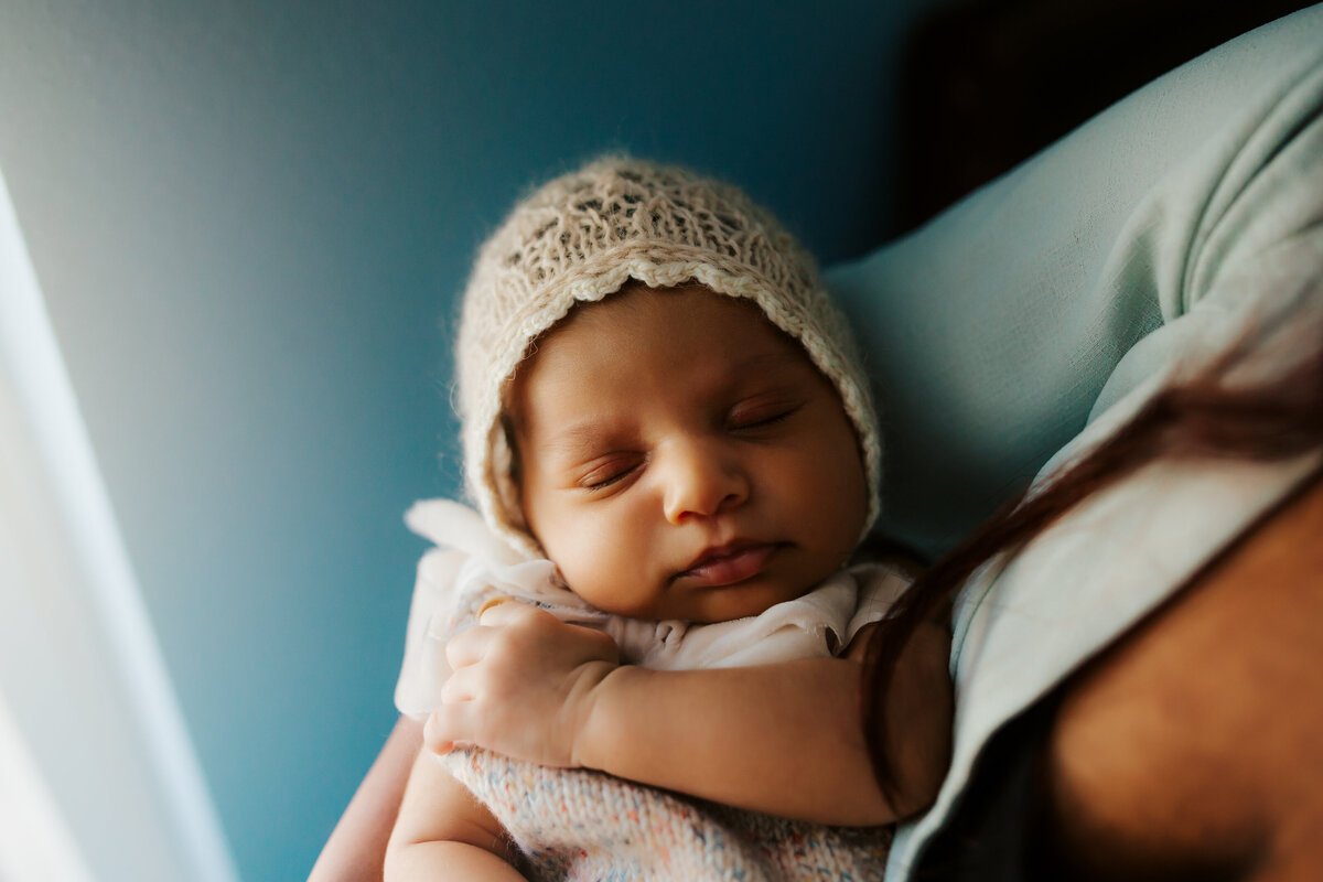 beautiful blue hues with natural window light and a newborn baby with a crochey bonnet on