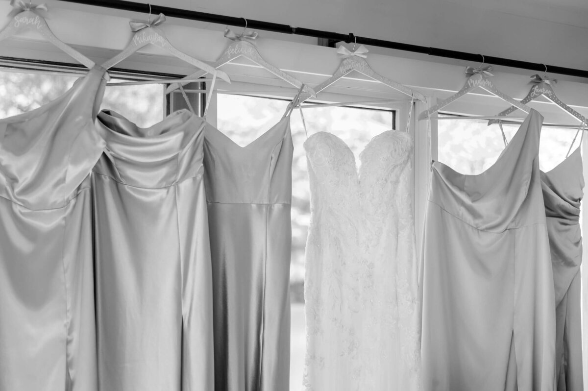Bridal gowns hanging in natural light, a timeless wedding dress photo captured by Pittsburgh wedding photographer, Bree Stewart.