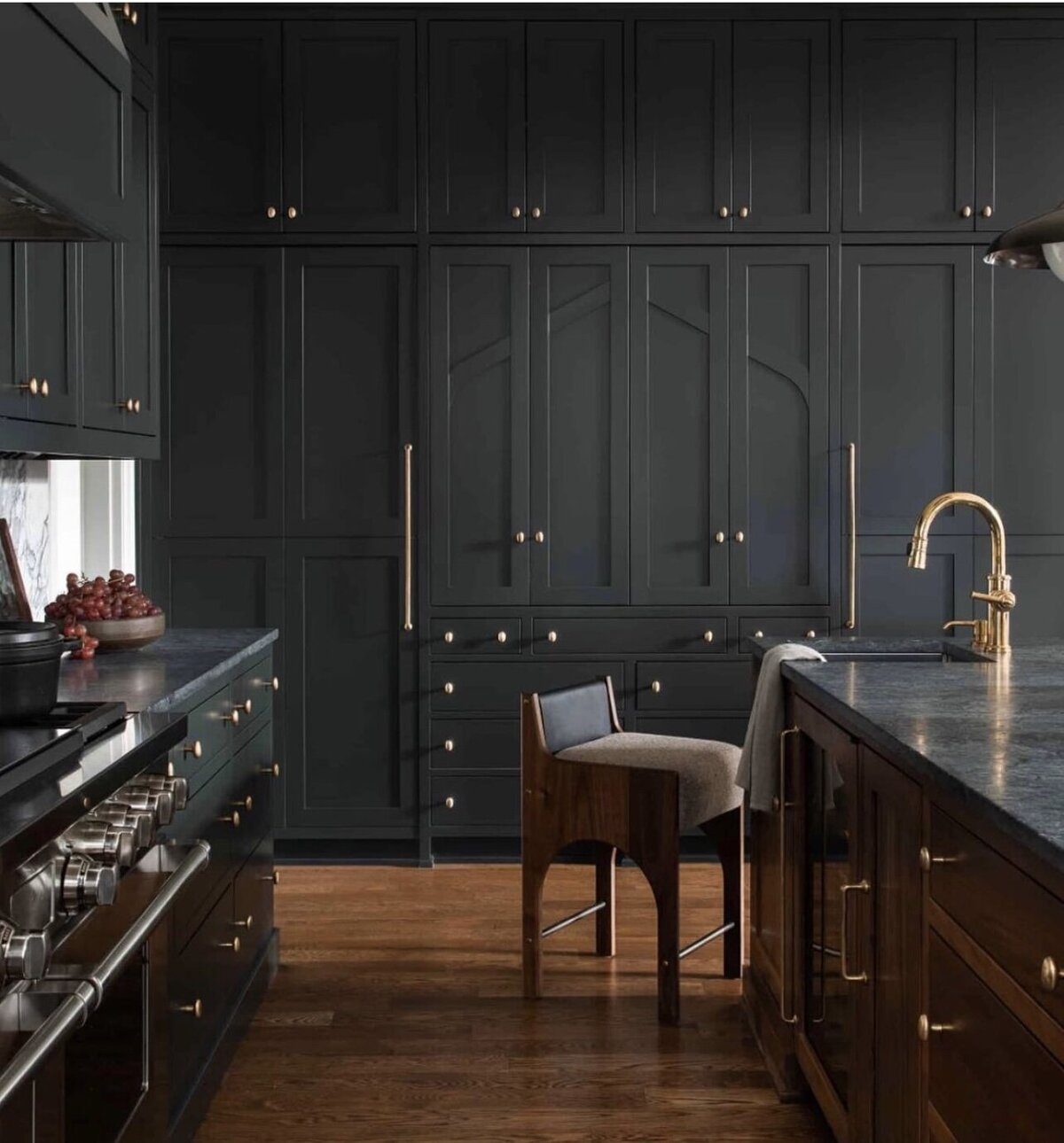 Beautiful kitchen with dark cabinets and gold hardware trendy for remodels shown by Craig Lerch