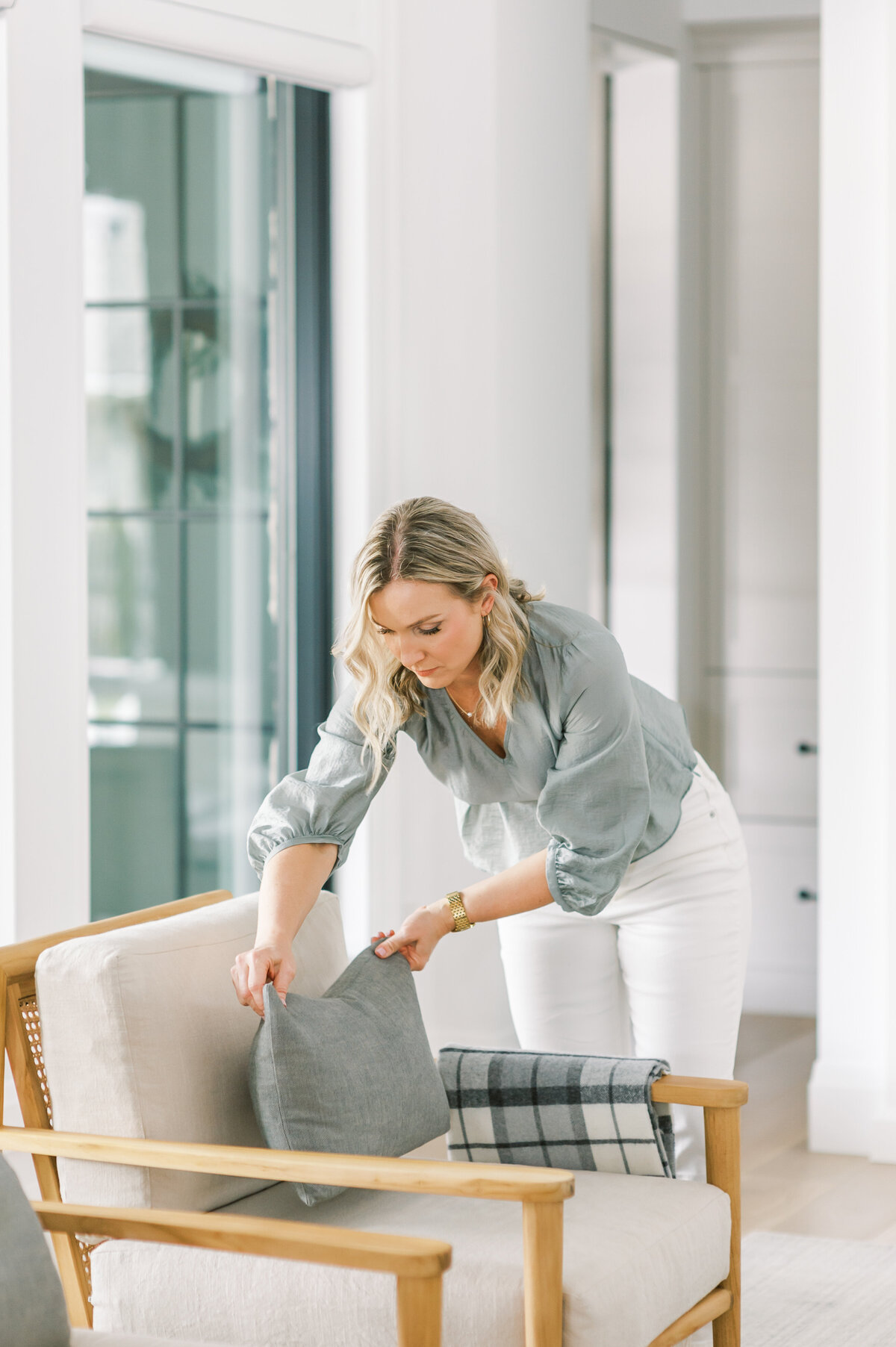 Top Sarnia, ON interior designer arranges pillows in her Sarnia, Ontario home.