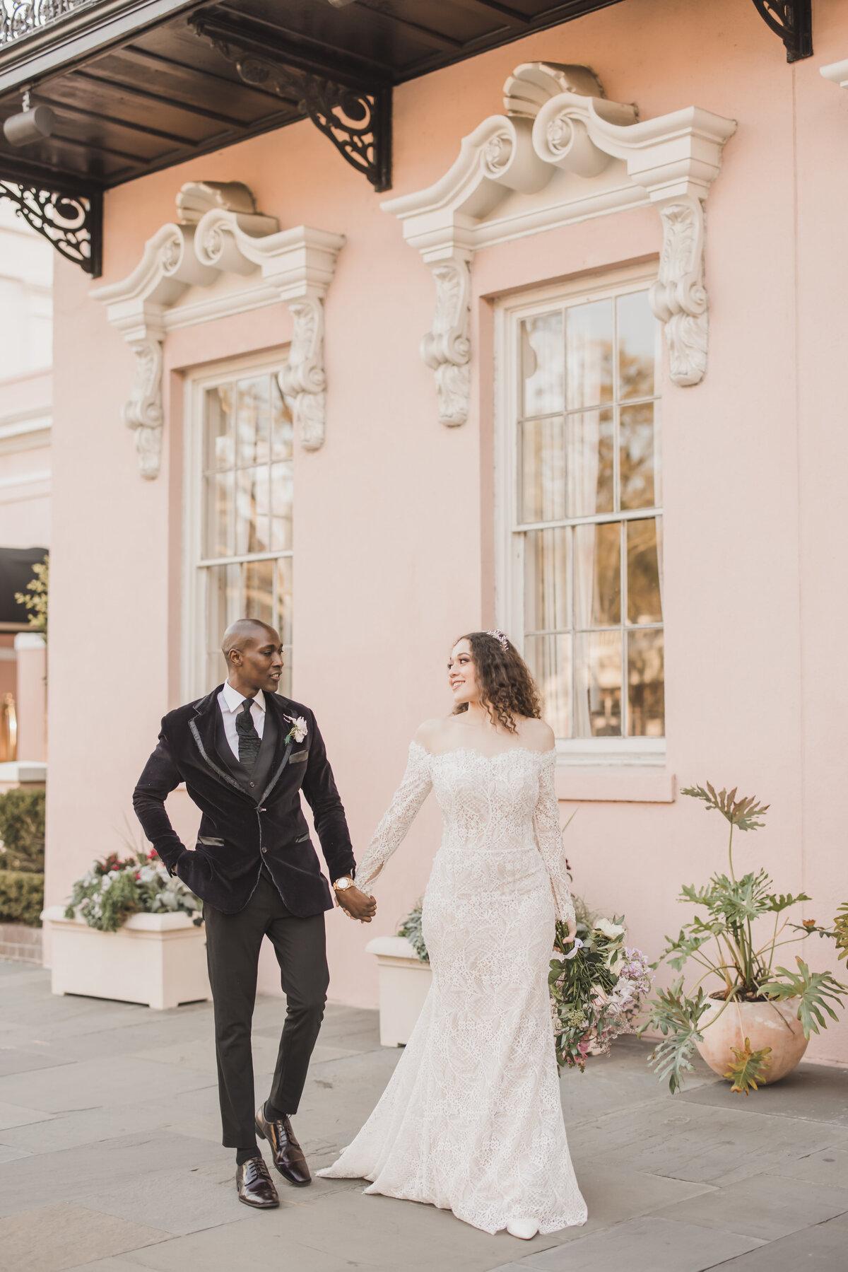 Wedding Photographer & Elopement Photographer Husband and wife hold hands outside of elegant venue