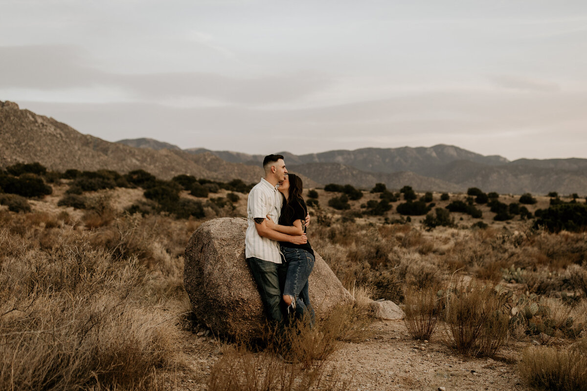 engaged couple huggin the the Albuquerque desert