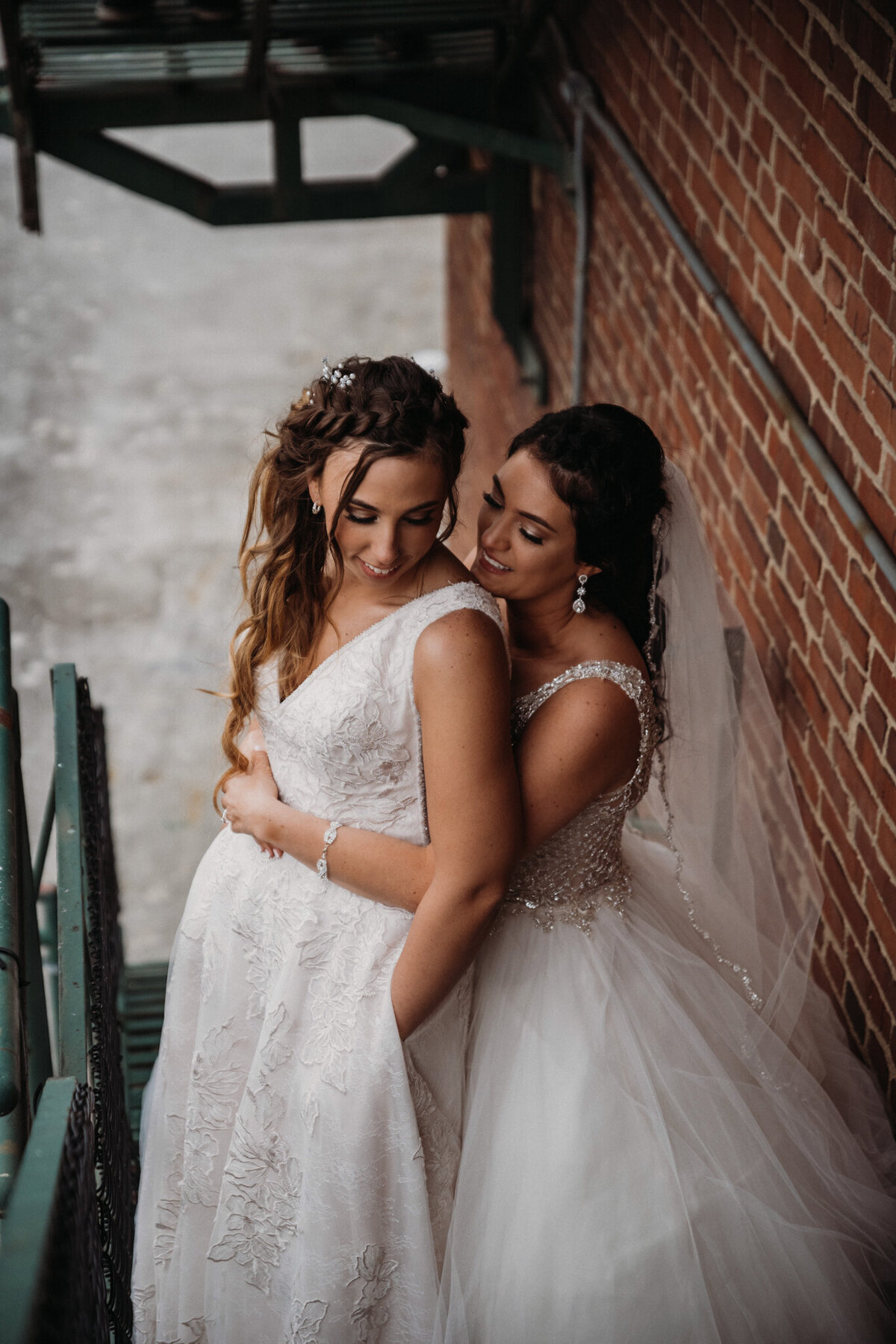 Brides cuddle at industrial setting in Akron Ohio
