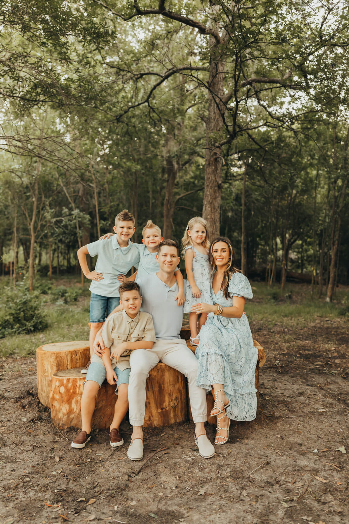 Brown family sits on a huge tree stump at Memorial Hermann Park for Ally's Photography