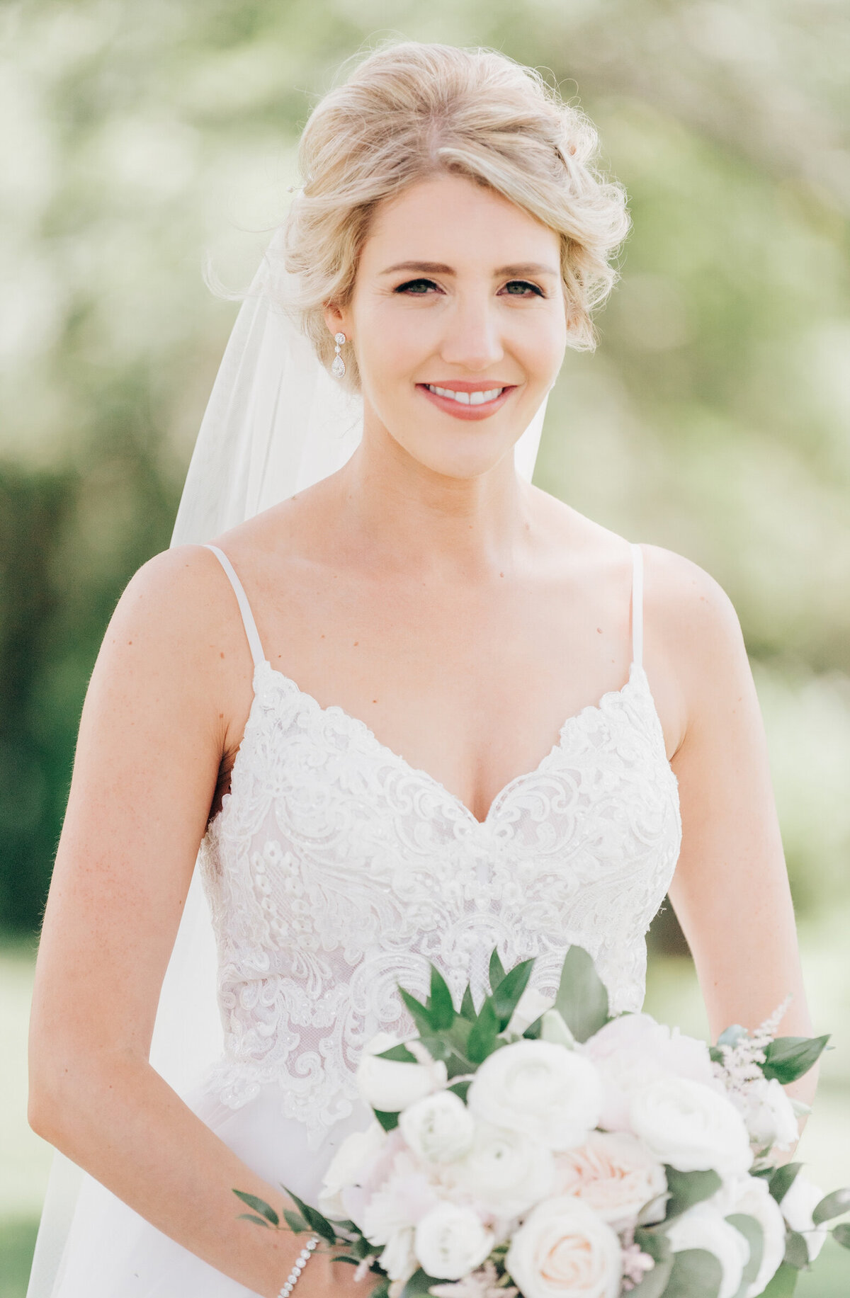 Elegant portrait of beautiful bride holding bouquet of white florals and eucalyptus