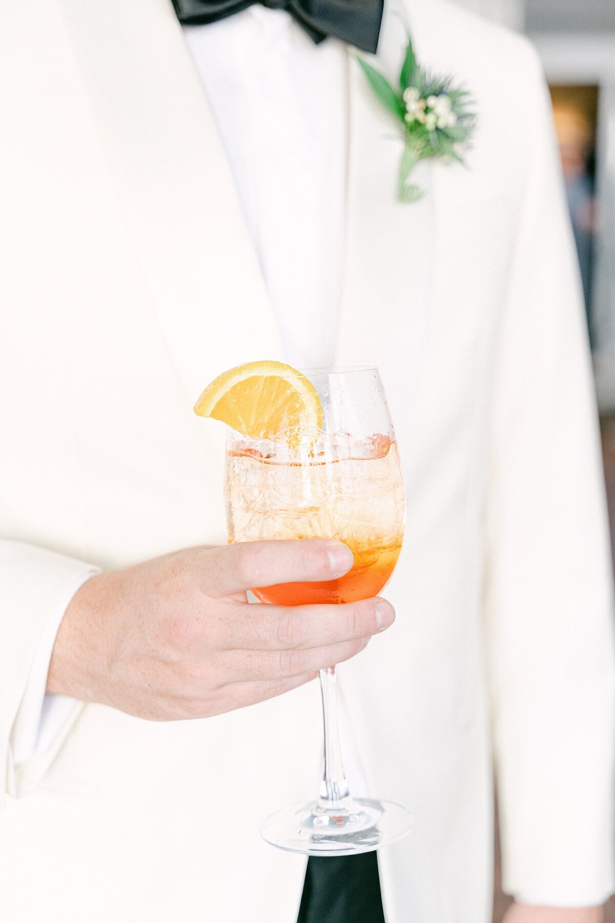 Groom holding an aperol spritz at his wedding at Hyannisport Club in Cape Cod