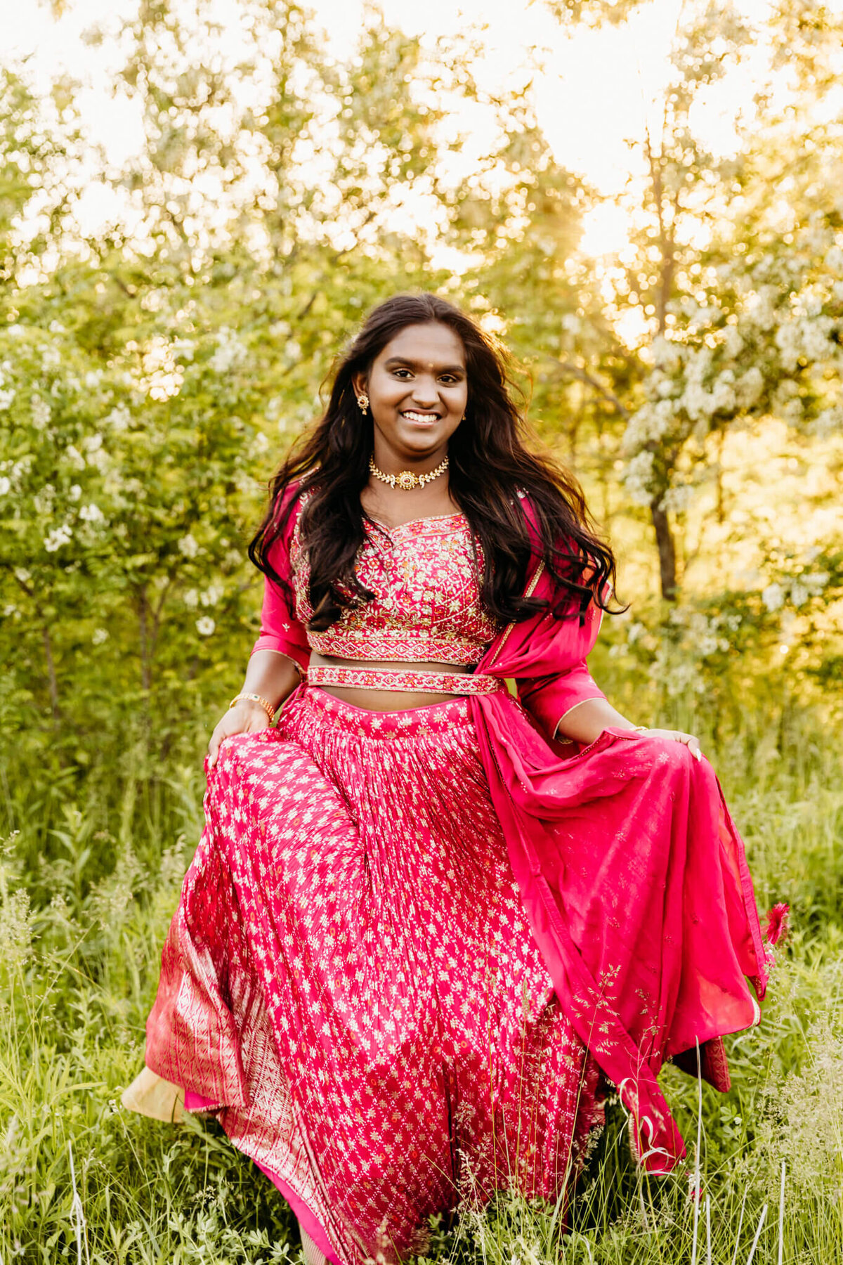 Gorgeous high school girl in a red traditional outfit smiling and running captured by Ashley Kalbus Photography