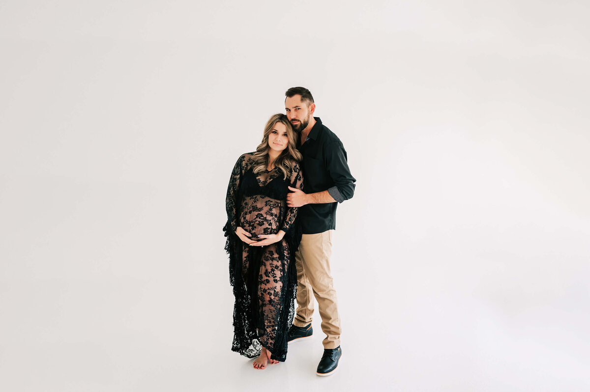 pregnant couple standing next to each other  during maternity photography session in Branson