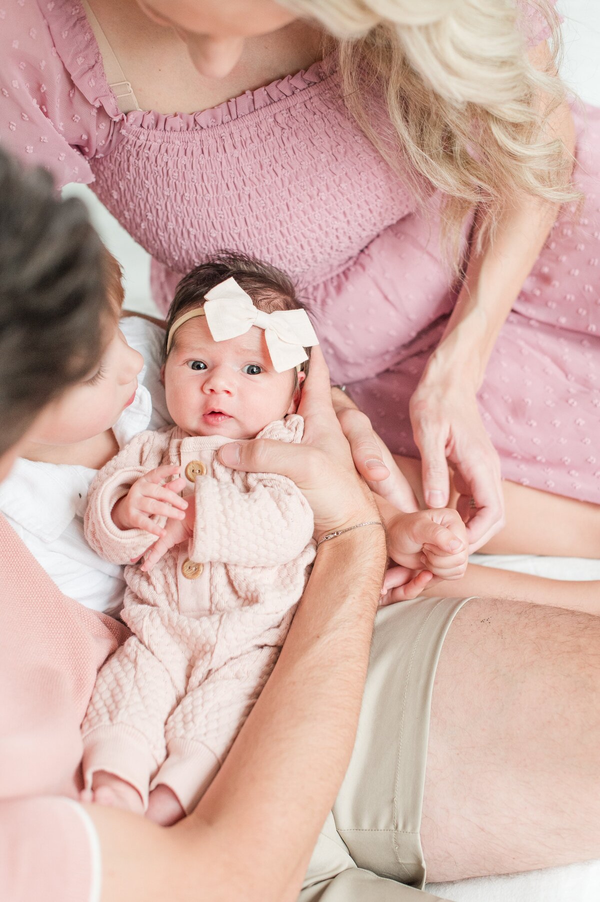 newborn baby girl on mom and dad's arm