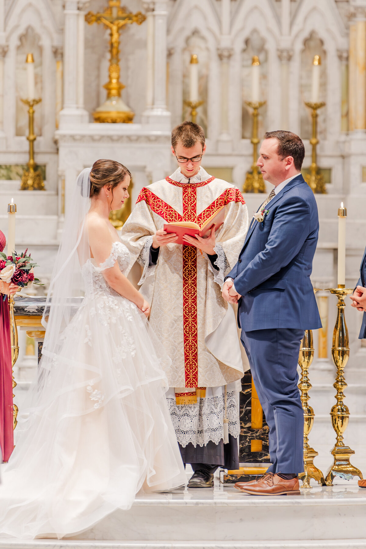 bride and groom facing each other at catholic church altar getting married